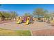 Community playground with colorful slides, climbing structures, and shaded picnic area on a sunny day at 19242 W Madison St, Buckeye, AZ 85326