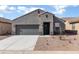 Charming single-story home with a neutral exterior, a well-maintained front yard, and an attached two-car garage at 20670 N Confetti Ct, Maricopa, AZ 85138