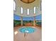 Indoor hot tub featuring an artistic mural view, pillars, wood ceiling, tile and arched windows at 20670 N Confetti Ct, Maricopa, AZ 85138