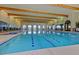 Indoor pool featuring blue and white tiles, with ceiling wood beams and arched windows at 20670 N Confetti Ct, Maricopa, AZ 85138