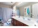 Well-lit bathroom featuring a single vanity with dark wood cabinets and a shower with curtain at 20784 N Marina Ave, Maricopa, AZ 85139