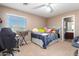 Bright bedroom with beige carpet, neutral walls, a window, and a door to an en-suite bathroom at 20784 N Marina Ave, Maricopa, AZ 85139