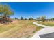 Well-maintained lawn area with a paved walking path, creating a serene outdoor space for residents at 20784 N Marina Ave, Maricopa, AZ 85139