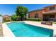 Lovely backyard pool featuring a lounge area for relaxation, set against a backdrop of mature trees at 20784 N Marina Ave, Maricopa, AZ 85139