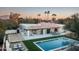 Aerial view of pool, patio, and backyard with outdoor kitchen and bocce court with mountain views at 22619 N La Senda Dr, Scottsdale, AZ 85255