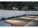 An outdoor bocce ball court is illuminated at night with tasteful landscaping and privacy wall at 22619 N La Senda Dr, Scottsdale, AZ 85255