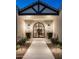 Elegant entryway with arched front door, flanked by sconces and manicured landscaping at 22619 N La Senda Dr, Scottsdale, AZ 85255