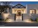 Exterior entrance featuring a black framed glass front door, desert landscaping, and modern wall lighting at 22619 N La Senda Dr, Scottsdale, AZ 85255