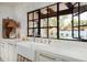 Bright kitchen featuring a farmhouse sink, marble countertops, and a view of the backyard at 22619 N La Senda Dr, Scottsdale, AZ 85255