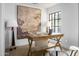 Bright home office with a large window, trestle desk and neutral color palette at 22619 N La Senda Dr, Scottsdale, AZ 85255