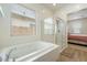 Well-lit bathroom shows a shower stall, bathtub, and a view to the primary bedroom at 22924 E Desert Spoon Dr, Queen Creek, AZ 85142