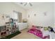 A bedroom featuring a bed with storage, a dollhouse, and a ceiling fan at 22924 E Desert Spoon Dr, Queen Creek, AZ 85142