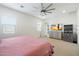 Spacious bedroom featuring a ceiling fan, TV, dresser, and a view into the ensuite bathroom at 22924 E Desert Spoon Dr, Queen Creek, AZ 85142