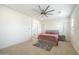 Bright bedroom boasts a large bed frame with storage, a ceiling fan, and an ensuite bathroom at 22924 E Desert Spoon Dr, Queen Creek, AZ 85142