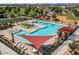 Stunning community pool area with lounge chairs, umbrellas, and shade sail at 22924 E Desert Spoon Dr, Queen Creek, AZ 85142