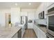 Spacious kitchen featuring white cabinetry, stainless steel appliances, and a large granite-top island at 22924 E Desert Spoon Dr, Queen Creek, AZ 85142