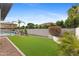 Spacious backyard featuring manicured artificial grass, mature trees, and an inviting fenced pool area at 253 W Malibu Dr, Chandler, AZ 85248