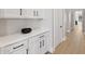 Hallway with built-in storage, white cabinets with black handles, and hardwood floors at 253 W Malibu Dr, Chandler, AZ 85248