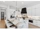 Modern kitchen island with marble countertop and seating, stainless appliances and black range hood at 253 W Malibu Dr, Chandler, AZ 85248