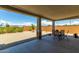 Covered patio features a table, chairs, and view of the yard, perfect for outdoor dining at 27366 W Escuda Dr, Buckeye, AZ 85396