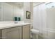 Well-lit bathroom with modern vanity, tub, and shower combo with white shower curtain at 27366 W Escuda Dr, Buckeye, AZ 85396