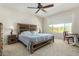 Bright bedroom with a natural wood bed frame and a view of desert foliage at 27366 W Escuda Dr, Buckeye, AZ 85396