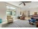 Inviting living room with plush seating, a ceiling fan and a view into the kitchen at 27366 W Escuda Dr, Buckeye, AZ 85396