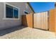 View of side yard with gate, cinder block wall, window, and pea gravel surface at 27366 W Escuda Dr, Buckeye, AZ 85396