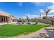 Expansive backyard with a sparkling pool, lounge seating, and lush green grass at 3095 E Cardinal Ct, Chandler, AZ 85286