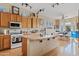 Well-lit kitchen features wood cabinetry, a central island, and stainless steel appliances, perfect for cooking at 3095 E Cardinal Ct, Chandler, AZ 85286