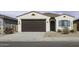 Charming single-story home with a brown garage door, blue accents, and desert landscaping at 35378 W Santa Barbara Ave, Maricopa, AZ 85138