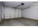 Spacious two-car garage, with an automatic door and concrete flooring at 35378 W Santa Barbara Ave, Maricopa, AZ 85138