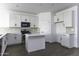 Bright kitchen featuring white cabinets, stainless steel appliances, and a center island, perfect for cooking at 35378 W Santa Barbara Ave, Maricopa, AZ 85138