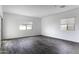 Bright living room with grey wood-look flooring and windows at 35378 W Santa Barbara Ave, Maricopa, AZ 85138