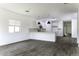 Open-concept living space with kitchen view, features gray wood flooring at 35378 W Santa Barbara Ave, Maricopa, AZ 85138