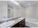 Bright bathroom featuring double sinks, granite countertops, and a soaking tub at 38179 W La Paz St, Maricopa, AZ 85138