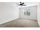 Neutral bedroom featuring a ceiling fan, carpeted flooring, and natural light at 38179 W La Paz St, Maricopa, AZ 85138