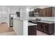 Well-equipped kitchen featuring granite countertops, stainless steel appliances, and dark wood cabinetry at 38179 W La Paz St, Maricopa, AZ 85138