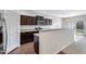 Modern kitchen with dark cabinetry, stainless steel appliances, and granite countertops at 38179 W La Paz St, Maricopa, AZ 85138