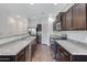 Contemporary kitchen featuring stainless steel appliances, granite countertops, and dark wood cabinetry at 38179 W La Paz St, Maricopa, AZ 85138