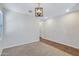 Bright living room with carpeted floors, recessed lighting, and a modern, decorative light fixture at 38179 W La Paz St, Maricopa, AZ 85138