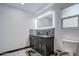 Bright bathroom featuring a double sink vanity, decorative stone backsplash, and a window for natural light at 3915 E Hillery Dr, Phoenix, AZ 85032