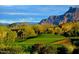 Picturesque golf green with red flag and a backdrop of stunning mountain views and desert flora on a sunny day at 4109 N Twilight Cir, Mesa, AZ 85207