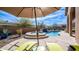 Relaxing backyard oasis featuring a sparkling pool, water feature, and comfortable lounge chairs under an umbrella at 4109 N Twilight Cir, Mesa, AZ 85207