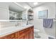 Bright bathroom with wood-look vanity and white countertop, a mirror, and glass door shower at 4857 N Granite Reef Rd, Scottsdale, AZ 85251