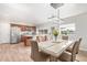 Bright dining area features a modern light fixture, a large table with six chairs, and flows into the kitchen at 4857 N Granite Reef Rd, Scottsdale, AZ 85251