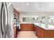 Well-lit kitchen features stainless steel appliances, wood cabinetry, ample counter space, and a view to the backyard at 4857 N Granite Reef Rd, Scottsdale, AZ 85251