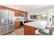 Spacious kitchen featuring stainless steel appliances, wood cabinets, an island with seating, and a pass-through window at 4857 N Granite Reef Rd, Scottsdale, AZ 85251