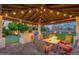 Outdoor living space featuring a covered patio with a fire pit table, bar, putting green, and backyard at 5020 E Pershing Ave, Scottsdale, AZ 85254