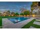 Backyard pool with a stone deck, mature citrus trees, lush grass, and accent lighting at 5020 E Pershing Ave, Scottsdale, AZ 85254